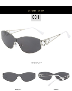 Detail view of silver heart-shaped hollow-out sunglasses with dark grey oversized lenses
