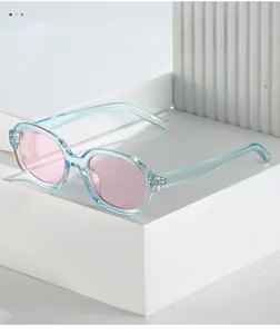 Detail of square sunglasses featuring light blue transparent frames and pink tinted lenses