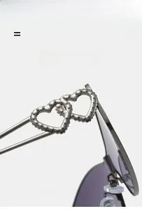 Detailed macro view of heart-shaped interlocking temples on lightweight metal sunglasses