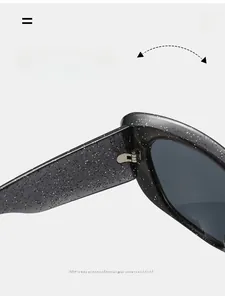 Detail of durable metal hinge on black cat-eye sunglasses with glitter starry texture