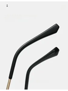 Macro view of ergonomic black eyeglass temples with gold metal hinge detail