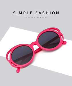 Detail of pink round sunglasses with hollow frame design on white geometric display stand