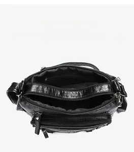 Detail view of large capacity crossbody bag showing multiple organized zipper compartments