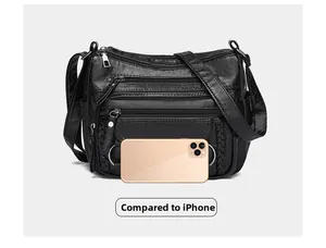 Detail view of multi-pocket black crossbody bag shown with a phone for size comparison