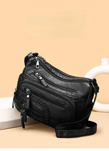 Detail showing multi-layer zipper compartments and woven PU leather texture on black tote