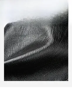 Macro shot of high-quality black lychee texture leather with soft flexible surface