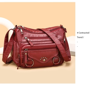 Detail view of burgundy faux leather crossbody bag with metal ring and lychee texture