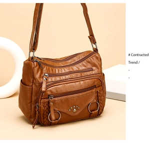 Close-up of brown PU leather shoulder bag featuring multiple zipper pockets and texture