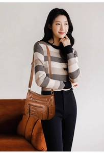 Detail of a brown retro PU leather shoulder bag with multiple zipper pockets and braided side