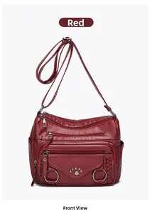Detailed front view of a multi-zipper red leather shoulder bag with metallic accents