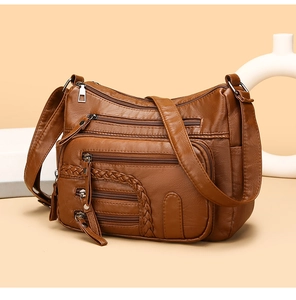 Detail view of brown woven PU leather shoulder bag with multiple functional zippers