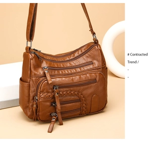 Close-up of dark brown multi-pocket crossbody bag with woven details and zippers