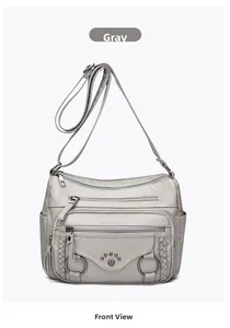 Front detail of grey multi-zippered crossbody bag with textured pebble leather finish