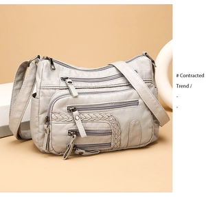 Detail of multi-zippered crossbody bag in soft beige PU leather with woven texture design