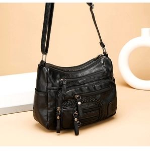 Detailed view of black woven texture on multi-pocket shoulder bag with soft leather finish