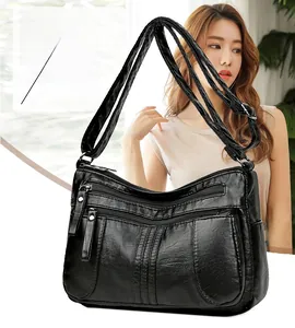 Detail of black soft leather crossbody bag with multiple zip pockets and adjustable strap