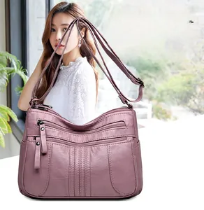 Detail of purple soft leather shoulder bag with multiple zippered pockets and lychee texture