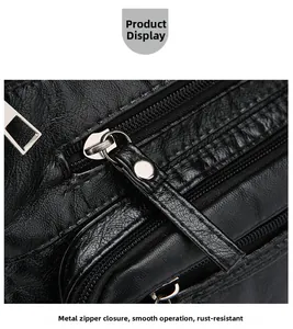 Close-up of smooth hardware zippers and litchi grain leather texture on black handbag