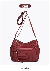 Detailed view of red crossbody bag with multiple zippers and woven texture details