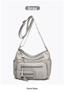 Close-up of grey woven shoulder bag showing multiple zipper pockets and soft texture