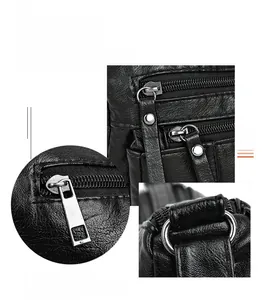 Detailed macro view of black lychee leather texture and silver zipper hardware on bag