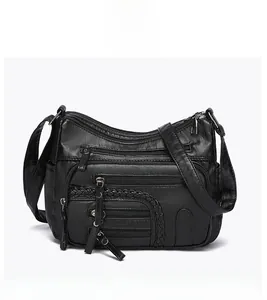 Front detail of black multi-pocket shoulder bag featuring woven leather trim and zippers