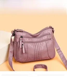 Detail view of the soft faux leather crossbody bag with multiple front zipper pockets