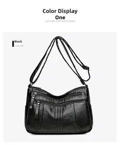 Detail view of black soft leather crossbody bag featuring multiple front zipper pockets
