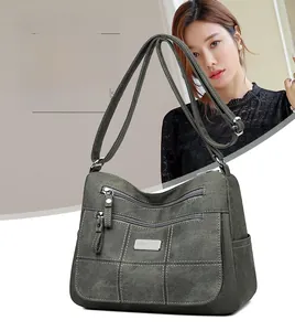 Close-up of olive green crossbody bag with multi-pocket design and grid stitching detail