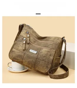 Detail view of brown vintage shoulder bag with multiple zippers and textured material