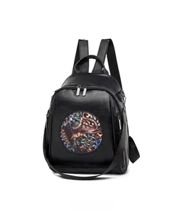 Detail view of the black leather backpack featuring vintage elephant embroidery and side pocket