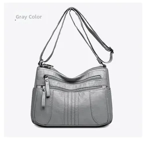Detailed view of gray PU leather shoulder bag featuring multiple functional front zippers