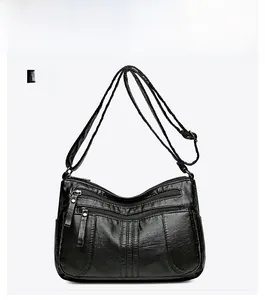 Front view of black multi-zippered soft leather crossbody bag with adjustable strap