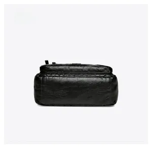 Detail view showing the flat bottom of the black soft leather shoulder bag with fine stitching