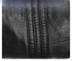 Close-up of black leather bag with premium grain texture and parallel stitching detail