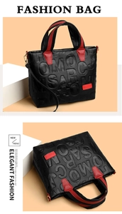 Detail of embossed lettering on litchi grain leather tote bag with red handles