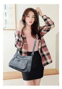 Detail of dark grey multi-pocket crossbody bag with adjustable strap and matte finish