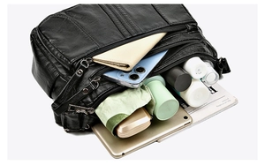 Detailed view of spacious black pebbled leather handbag with multiple storage compartments