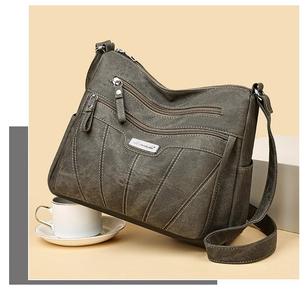 Detail of army green canvas multi-pocket shoulder bag with decorative stitching and metal logo