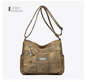 Close-up of vintage yellow crossbody bag showing dual zipper pockets and leather texture