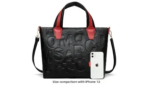 Black pebbled leather tote bag with red handles and size comparison to an iPhone 12
