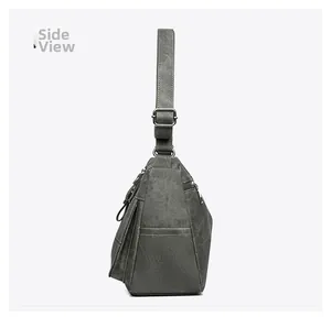 Side view of dark grey canvas crossbody bag with multiple pockets and adjustable strap