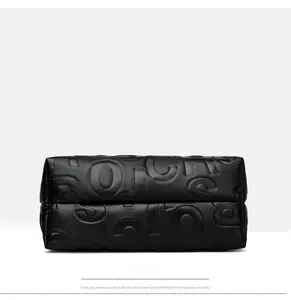 Detail view of the black leather tote bag base with premium embossed letters and stitching