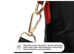 Detail of gold-plated strap hardware on black pebble leather tote with red edge finish