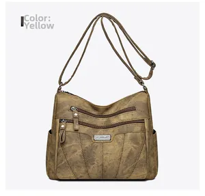 Detail view of yellow vintage faux leather crossbody bag with multiple zipper pockets