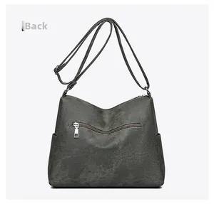 Detail view of the gray crossbody bag back featuring a zipper pocket and side pouches