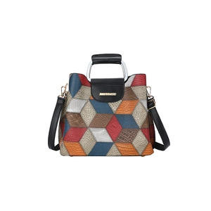 Detailed view of striped geometric patchwork bag with silver metal handles and logo