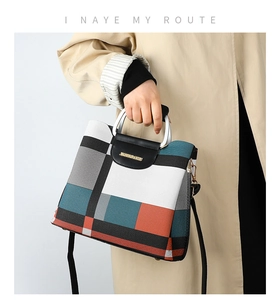 Detail of color-block crossbody bag with geometric patterns and metallic handle