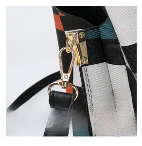 Detailed macro view of high-quality gold hardware on multi-color checkered canvas bag