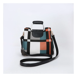 Detail of color-block striped crossbody bag with leather handle and detachable strap
